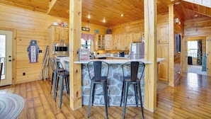 A wooden cabin with a stone island bar, wooden cabinets, and a bear-shaped welcome sign. - Spacious & Secluded Cabin: 25 Mi to Bentonville! (Sulphur Springs)