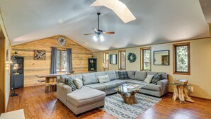 A spacious living room with a large sectional sofa, a wooden ceiling, and a ceiling fan. - Family-friendly House: Fish, Hike, Bike & More! (South Fork)