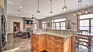 A spacious kitchen with wooden cabinets, a large island, and pendant lighting. - Cabin w/ Gradual Slope to Sandy Bottom Swimming! (Siren)
