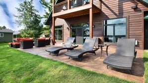 A wooden house with a balcony, outdoor seating area with chairs and a table, and a well-maintained lawn. - Cabin w/ Gradual Slope to Sandy Bottom Swimming! (Siren)