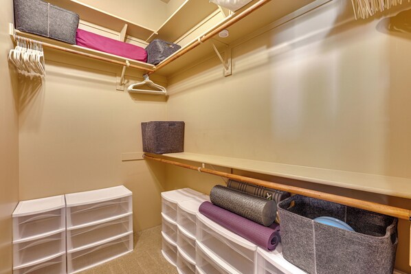 A closet with shelves, hanging space, and storage bins.