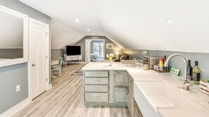 A modern kitchen with a central island, a dining area, and a cozy seating space. - Benton Harbor Apt w/ Balcony + Fire Pit (Benton Harbor)