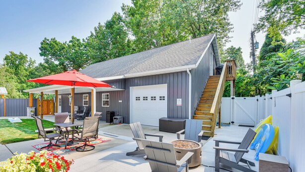 A covered patio with outdoor furniture, a fire pit, and a red umbrella. - Benton Harbor Apt w/ Balcony + Fire Pit (Benton Harbor)
