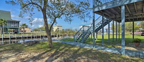 A park with a wooden deck, a staircase, and a pathway leading to a water body.