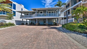 A modern multi-story building with a spacious covered entrance and a brick-paved courtyard.