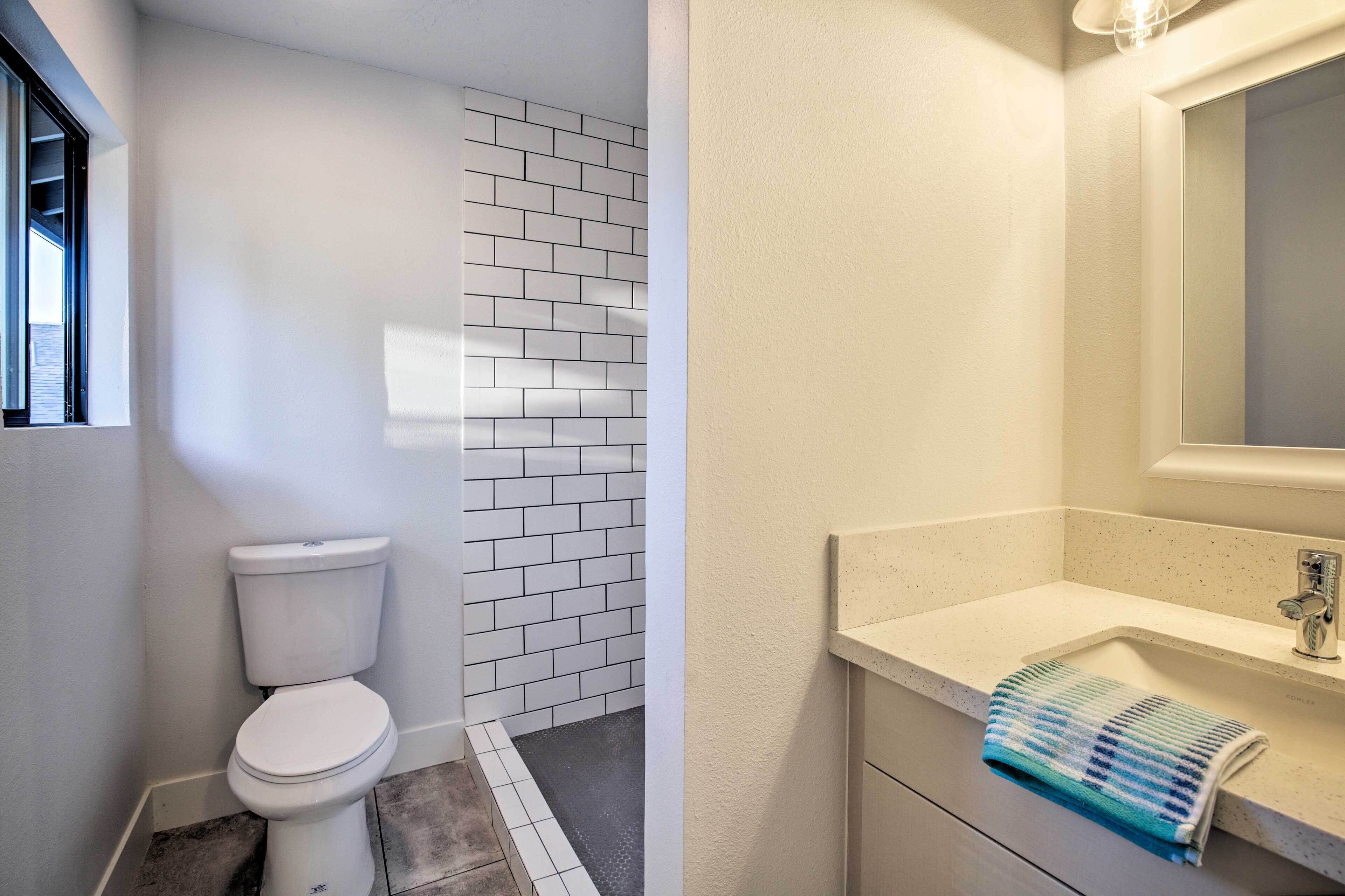 A bathroom with a toilet, a sink, and a mirror.