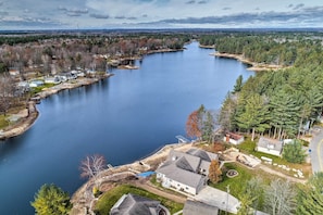 Un lac entouré de maisons, dont certaines ont des allées et des jardins bien visibles.
