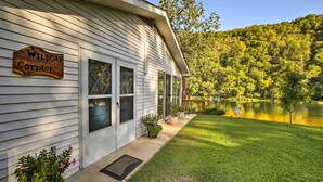 A house with a sign reading "Wildcat Cottage" and a view of a lake.