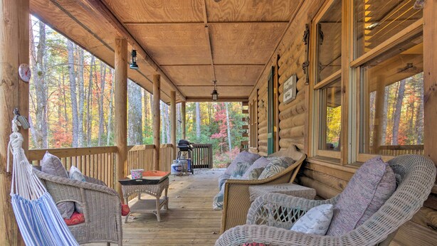 A wooden deck with wicker furniture and a hammock. - Cedar Mountain Log Cabin: 4 Mi Dupont State Forest (Brevard)