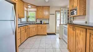 A kitchen with wooden cabinets, a refrigerator, a microwave, and a stove. - Sunrise Bay w/ Lake Access: Families Welcome! (Isanti)