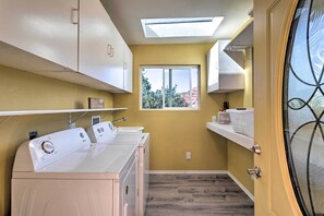 A laundry room with a skylight, a window, and a door with a decorative glass panel. - Wraparound Balcony & Mtn Views: Home in Sedona (Sedona)