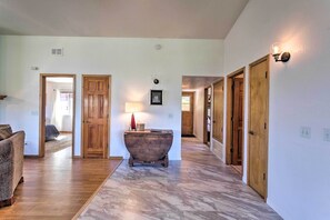 Un pasillo amplio con puertas de madera, una bañera antigua y una lámpara.