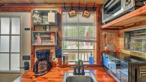 A kitchen with wooden cabinets, a coffee maker, a microwave, and a toaster. - 'the Gosling' Studio Cabin w/ River Access! (New Bern)