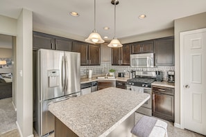A modern kitchen with stainless steel appliances, granite countertops, and dark wood cabinets. - Charming Bellefonte Townhome Near Penn State! (Bellefonte)