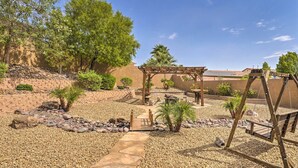 A garden with a wooden pergola, palm trees, and a stone pathway. - ~3,900 Sq Ft North Vegas Escape w/ RV Parking! (North Las Vegas)
