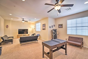 A living room with a ping pong table, two sofas, a TV, ceiling fans, and exercise equipment. - ~3,900 Sq Ft North Vegas Escape w/ RV Parking! (North Las Vegas)