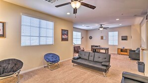 A living room with a ceiling fan, a sofa, a chair, and a dining area with a table and chairs. - ~3,900 Sq Ft North Vegas Escape w/ RV Parking! (North Las Vegas)