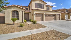 A two-story house with a beige stucco exterior, a tiled roof, and a front garage. - ~3,900 Sq Ft North Vegas Escape w/ RV Parking! (North Las Vegas)