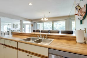 A modern kitchen with a wooden countertop, stainless steel sink, and a dishwasher. - Unwind Poolside! Lakefront Osage Beach Condo (Osage Beach)