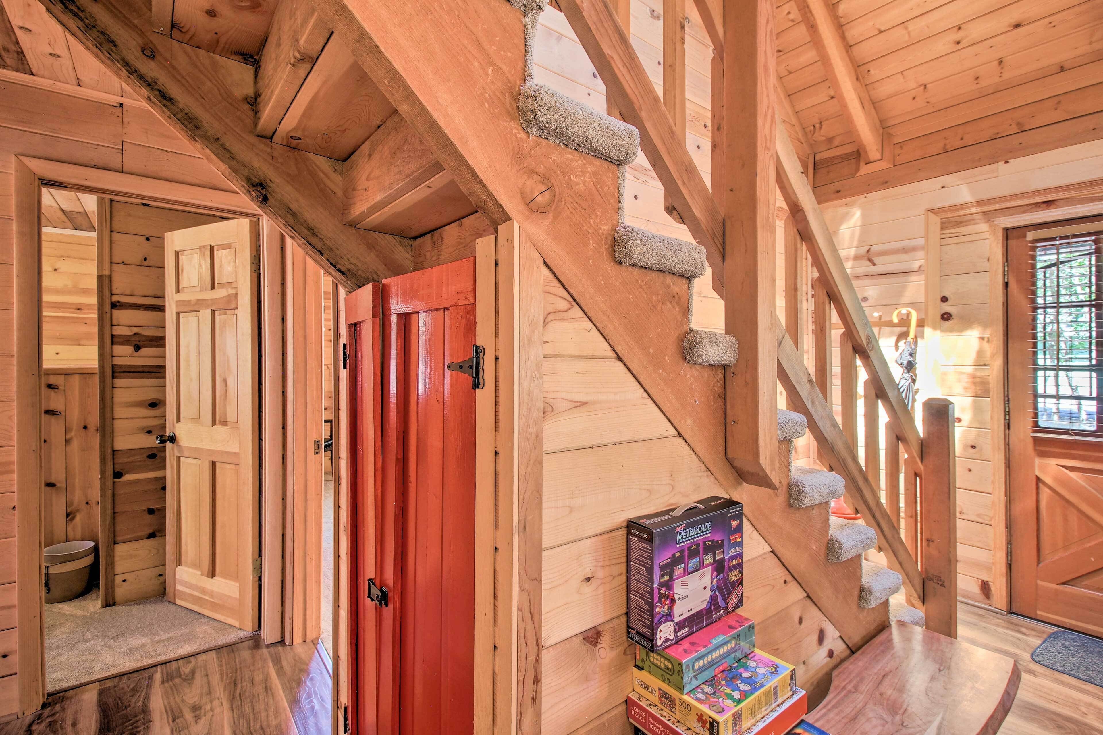A wooden staircase with a red door and a small table with toys.