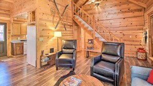 A log cabin interior with a kitchen, two leather chairs, a sofa, and a staircase. - Pinetop-lakeside Cabin w/ Deck: Hike, Ski & Golf (Pinetop)