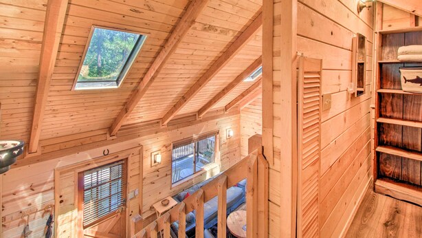 A wooden cabin interior with a loft bedroom, a dining area, and a small kitchen. - Pinetop-lakeside Cabin w/ Deck: Hike, Ski & Golf (Pinetop)