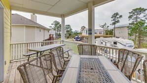 A covered outdoor patio with wicker furniture, a table, and chairs. - Orange Beach Family Duplex w/ Deck < 1 Mi to Shore (Orange Beach)