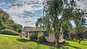 A single-story house with a porch, surrounded by well-maintained lawns and trees. - Family-friendly Coatesville House w/ Fire Pit (Coatesville)