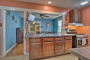 A kitchen with wooden cabinets, a built-in stove, and a ceiling fan. - Suburban Home w/ Backyard Patio < 7 Mi to Dtwn! (Lansdowne)