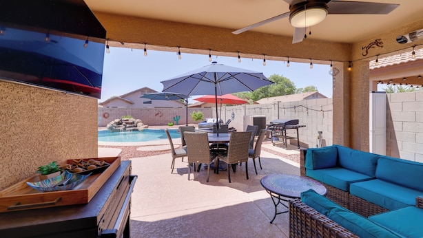 Un patio techado con piscina, mobiliario exterior y zona de barbacoa.