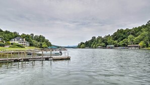 En sjö med en brygga, ett hus och en båt.