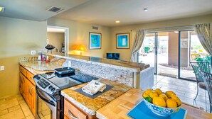 A kitchen with granite countertops, a stove, and a bowl of fruit on the counter. - Carefree Casita w/ Outdoor Pool & Mountain View! (Carefree)