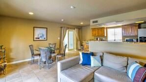 A living room with a sofa, chairs, a dining table, and a kitchen area with cabinets and appliances. - Carefree Casita w/ Outdoor Pool & Mountain View! (Carefree)