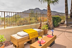 A balcony with a wooden bench, a yellow towel, and a glass with a red base. - Carefree Casita w/ Outdoor Pool & Mountain View! (Carefree)