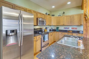 A modern kitchen with stainless steel appliances, wooden cabinets, granite countertops, and a built-in sink. - 'bozeman Getaway' w/ Mountain Views, Near Downtown (Bozeman)