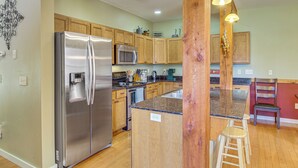 A kitchen with wooden cabinets, stainless steel appliances, a granite countertop, and a wooden stool. - 'bozeman Getaway' w/ Mountain Views, Near Downtown (Bozeman)