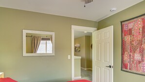 A bedroom with a bed, a door, a mirror, and a wall with a patterned tapestry. - 'bozeman Getaway' w/ Mountain Views, Near Downtown (Bozeman)