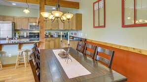 A dining area with a wooden table, chairs, and a chandelier. - 'bozeman Getaway' w/ Mountain Views, Near Downtown (Bozeman)