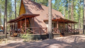 A cabin with a sloped roof, wooden deck, and a covered porch area. - The Silly Goose A-frame Cabin in Pinetop-lakeside (Pinetop)