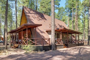 A cabin with a sloped roof, wooden deck, and a covered porch area. - The Silly Goose A-frame Cabin in Pinetop-lakeside (Pinetop)
