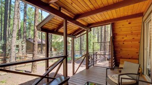 A wooden deck with a glass table and chairs, overlooking a forested area. - The Silly Goose A-frame Cabin in Pinetop-lakeside (Pinetop)
