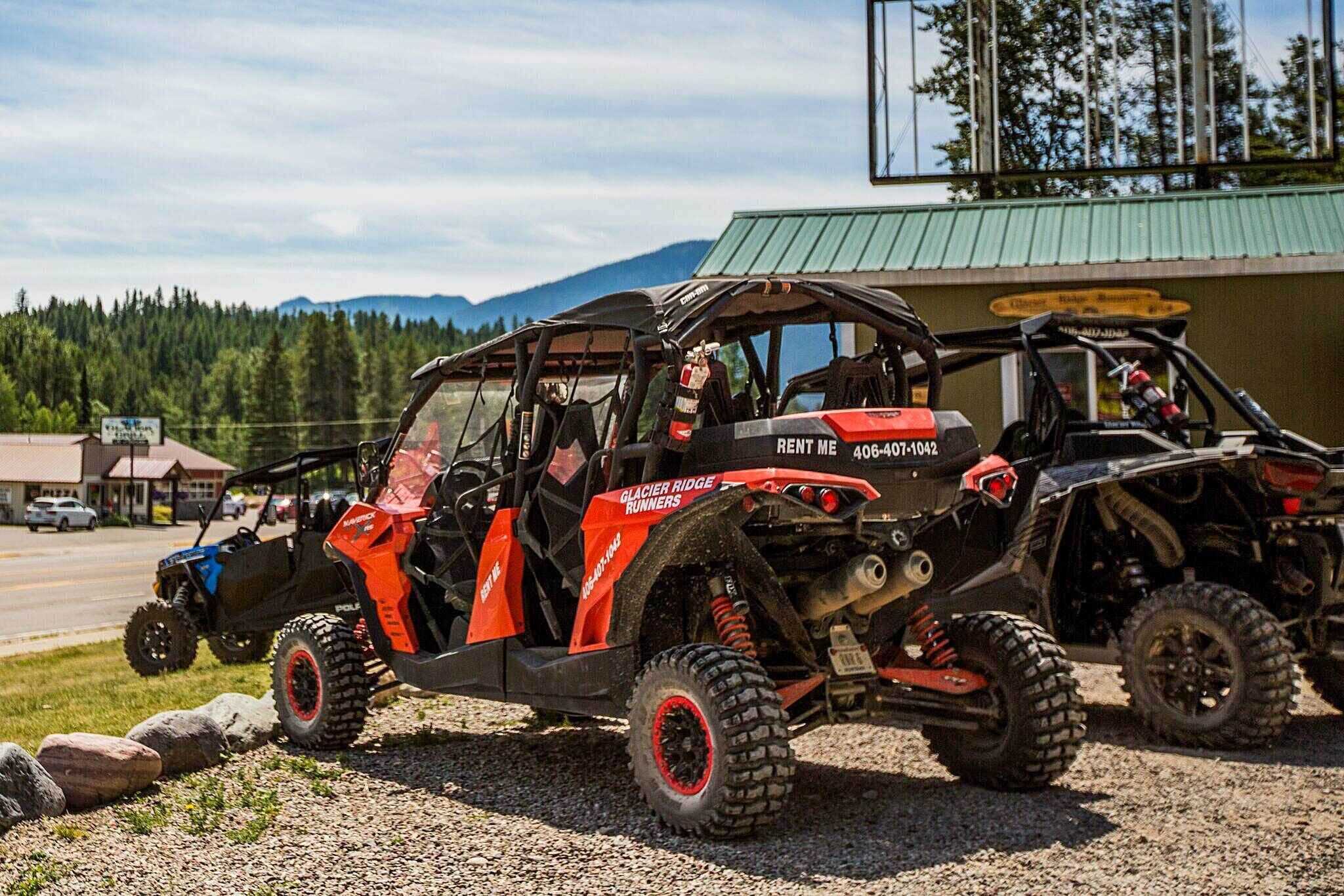 Two off-road vehicles parked in front of a building with a green roof.