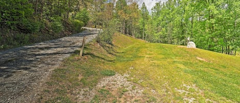 A gravel path leading through a grassy area with trees on both sides.