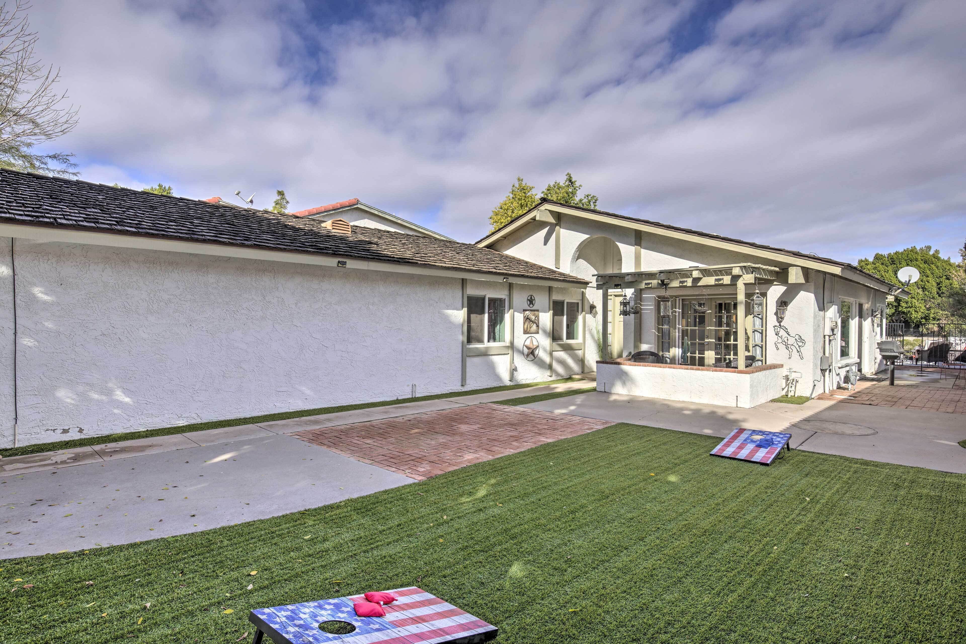 A building with a white exterior, a covered patio area, and a well-maintained lawn with American flag-themed items.