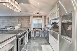 Una cocina moderna con estufa integrada, electrodomésticos de acero inoxidable y un comedor con mesa y sillas.