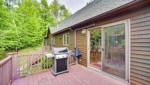 A wooden deck with a grill and patio furniture, overlooking a forested area. - Rustic North Creek Getaway ~ 4 Mi to Gore Mtn! (North Creek)