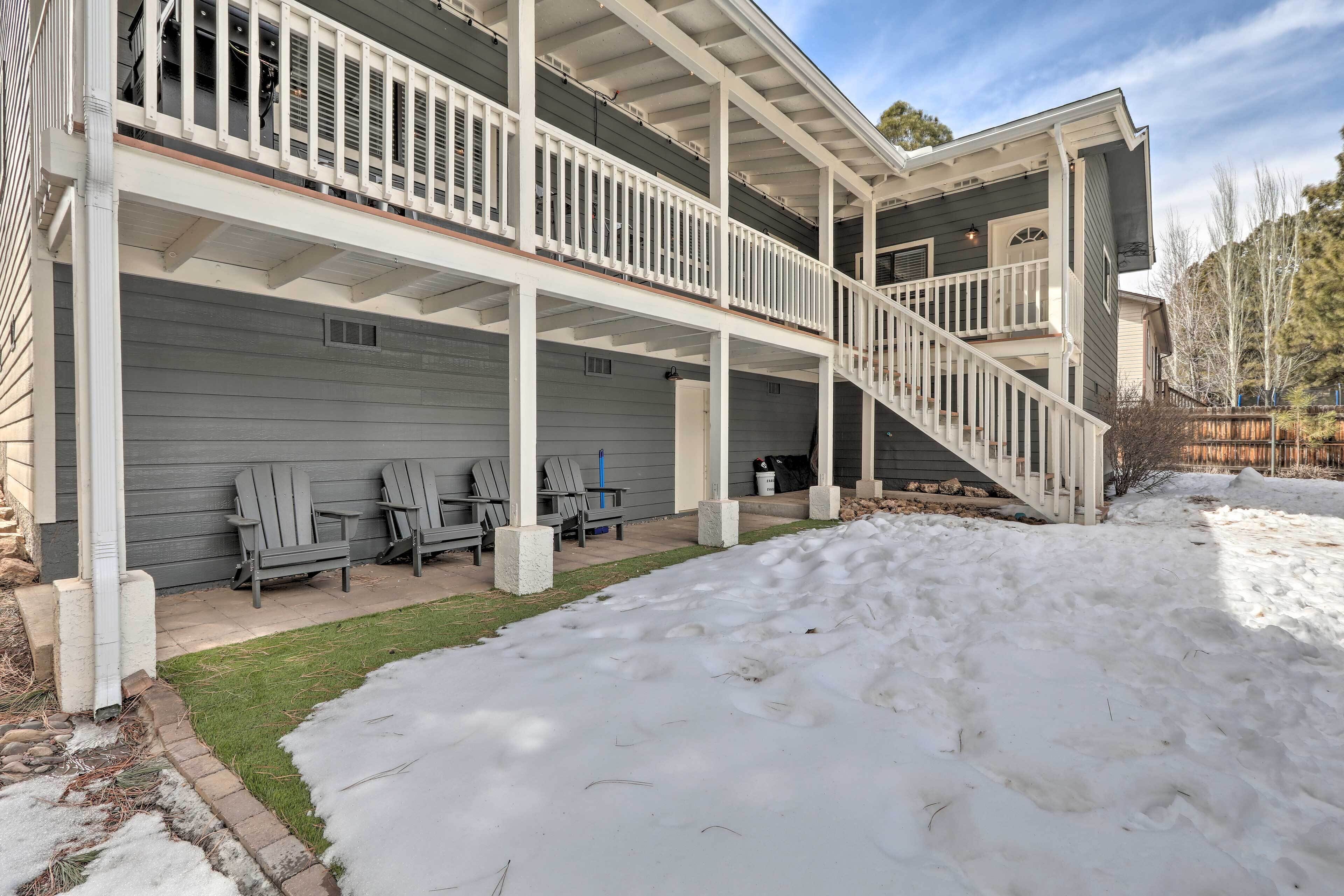 A two-story house with a covered porch and a staircase leading to the upper level.