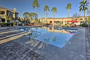 A swimming pool with lounge chairs and palm trees. - Patio & Resort Perks: Gated Gilbert Condo (Mesa)