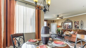 Un espace repas comprenant une table ronde, des chaises et un grand vase servant de centre de table.