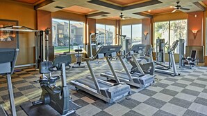 Une salle de sport équipée de tapis de course, de vélos elliptiques et d'appareils de musculation.
